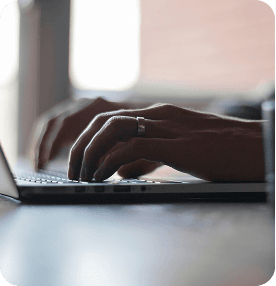 Hands typing on a laptop